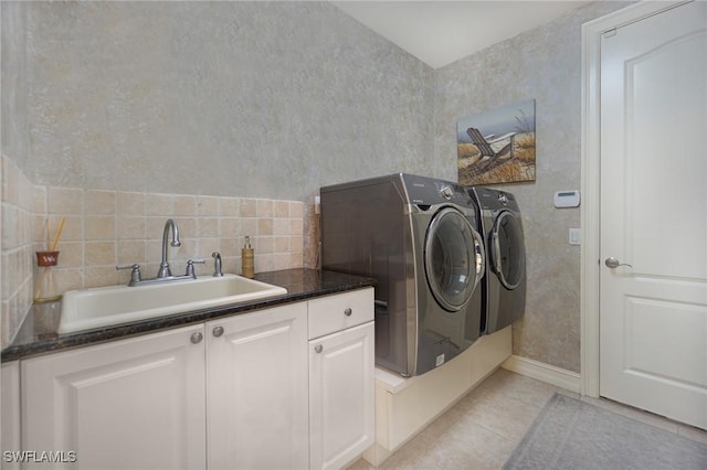 laundry area with light tile patterned flooring, cabinet space, a sink, and separate washer and dryer