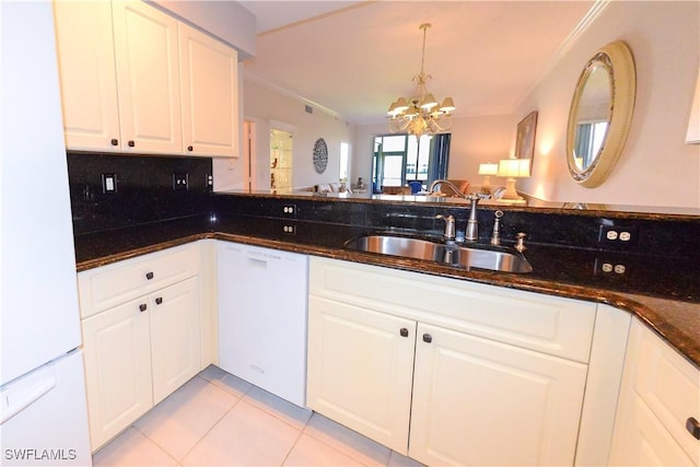 kitchen with dark stone counters, white appliances, a sink, and white cabinets