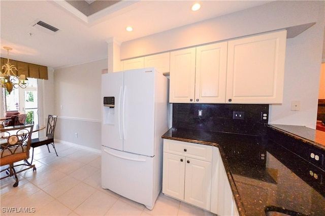 kitchen with white fridge with ice dispenser, visible vents, white cabinets, and a notable chandelier