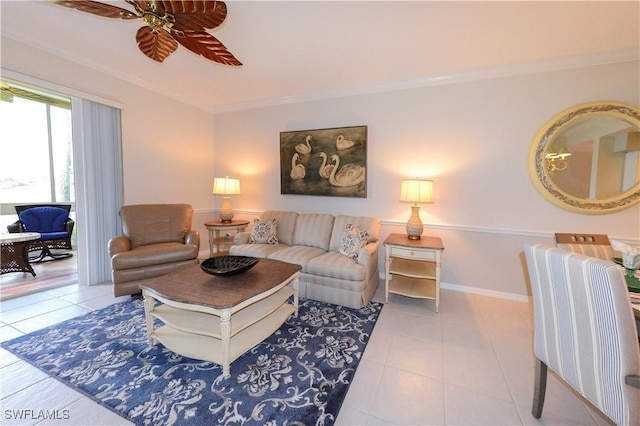 living room with baseboards, tile patterned flooring, a ceiling fan, and crown molding