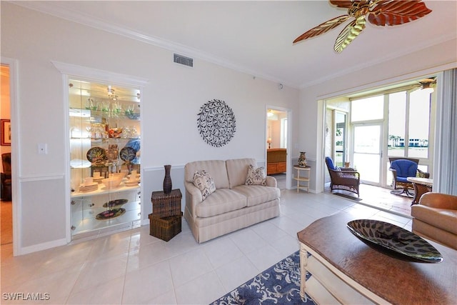 living area with a ceiling fan, visible vents, crown molding, and light tile patterned flooring