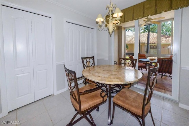 dining space with a chandelier, ornamental molding, light tile patterned floors, and baseboards