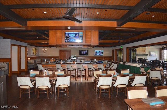 interior space with wood ceiling, a ceiling fan, beamed ceiling, and wood finished floors