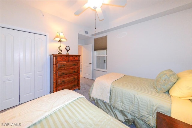 carpeted bedroom featuring ceiling fan, visible vents, and a closet