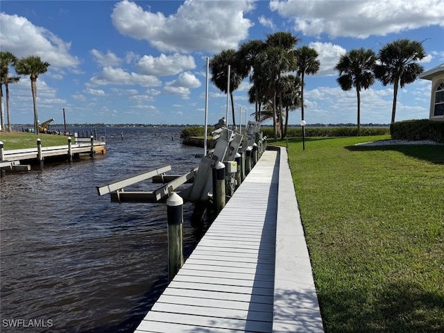 view of dock with a water view, a lawn, and boat lift