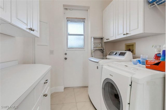 laundry area featuring cabinet space, washer and dryer, and light tile patterned flooring