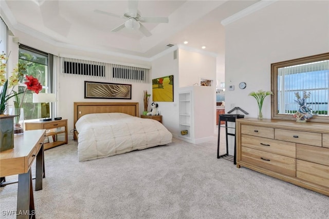 bedroom with a towering ceiling, ornamental molding, a raised ceiling, and light colored carpet