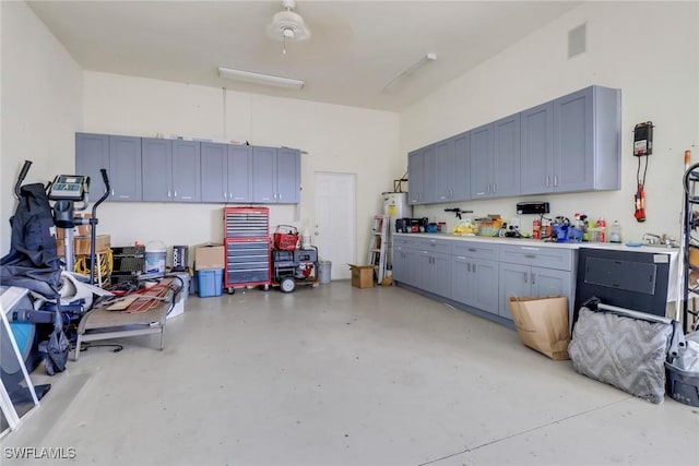 garage featuring water heater, visible vents, and a workshop area