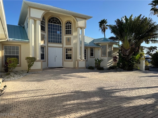 view of exterior entry featuring a standing seam roof, metal roof, and stucco siding