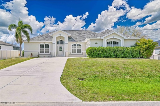 view of front of home with concrete driveway, a front lawn, and fence