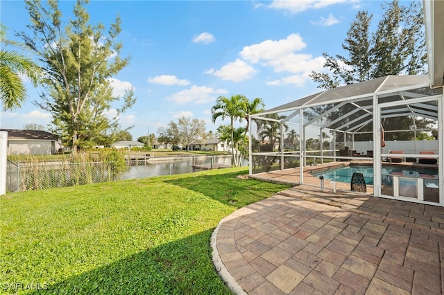 view of yard featuring a patio, a lanai, a water view, fence, and a fenced in pool