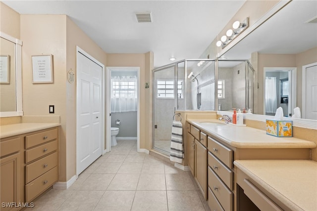 bathroom with visible vents, toilet, a stall shower, vanity, and tile patterned flooring