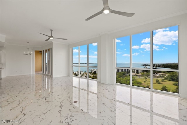 empty room with ceiling fan with notable chandelier, a water view, marble finish floor, ornamental molding, and a wealth of natural light