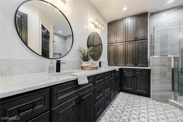 full bathroom featuring recessed lighting, a sink, a shower stall, and double vanity