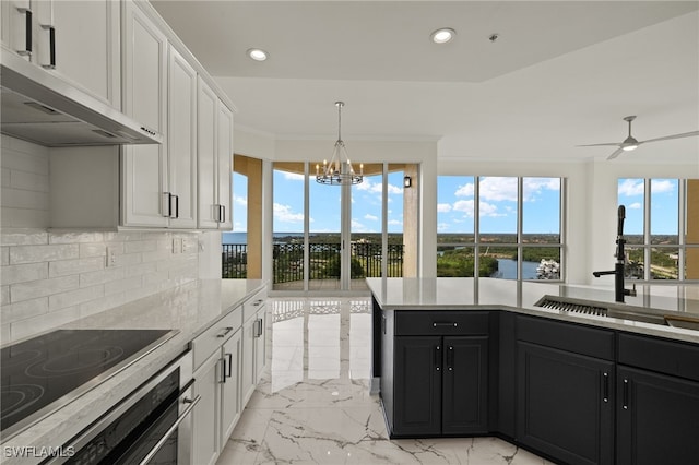 kitchen with cooktop, white cabinets, dark cabinets, and exhaust hood