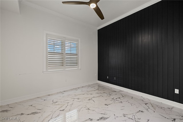 spare room featuring marble finish floor, ornamental molding, and baseboards