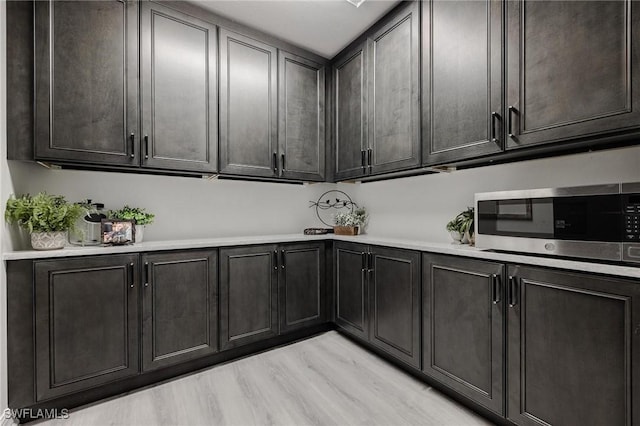 interior space with light wood-type flooring and stainless steel microwave