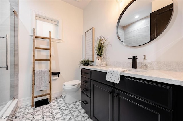 bathroom featuring baseboards, a shower with door, vanity, and toilet