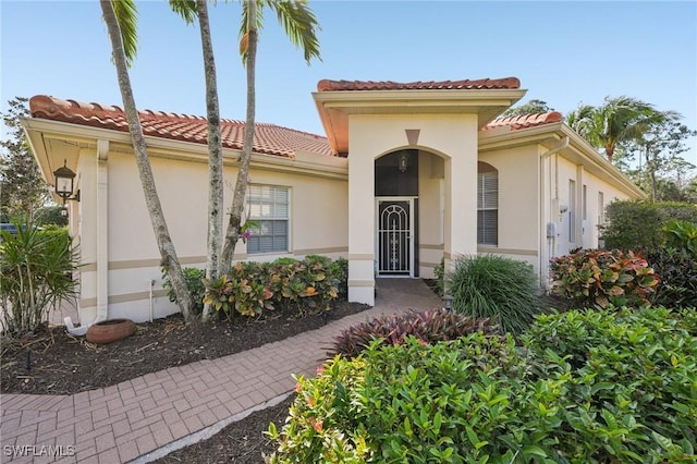 mediterranean / spanish-style house featuring stucco siding and a tiled roof