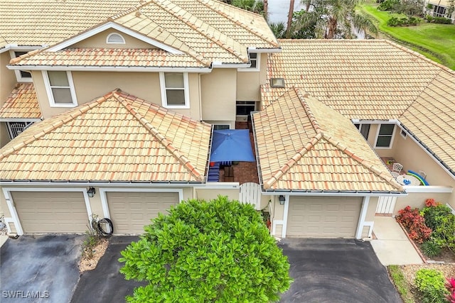 view of front of property featuring driveway, a tile roof, and stucco siding