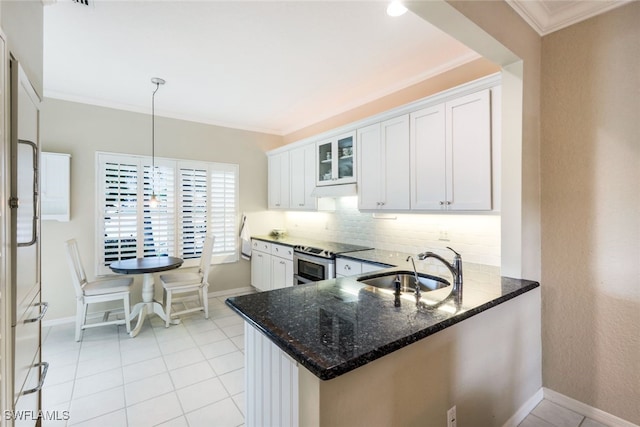 kitchen with white cabinets, glass insert cabinets, a peninsula, double oven range, and a sink