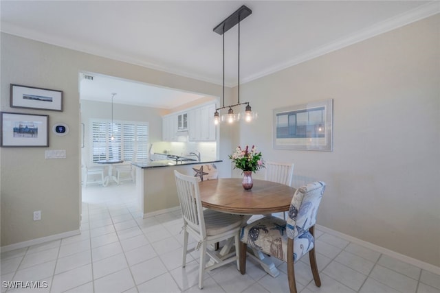 dining room featuring light tile patterned floors, baseboards, and crown molding