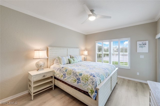 bedroom featuring light wood-style floors, baseboards, and ornamental molding