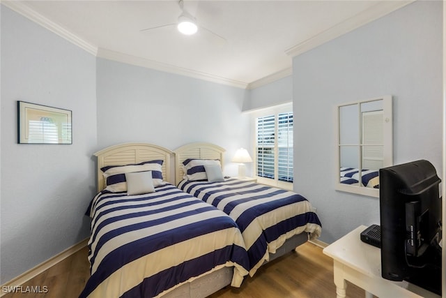 bedroom with baseboards, wood finished floors, and crown molding