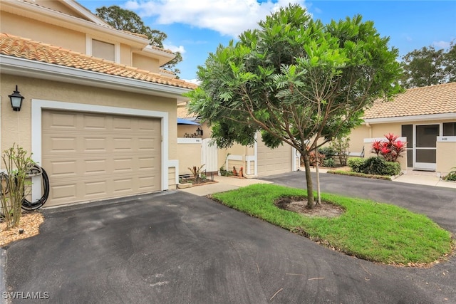 view of front of property with driveway, a tiled roof, and stucco siding