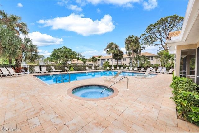 pool featuring a community hot tub, a patio area, and fence