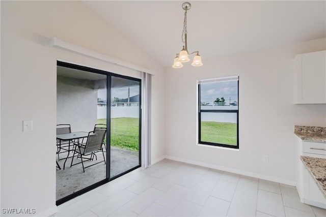 dining room with a wealth of natural light, a notable chandelier, vaulted ceiling, and baseboards