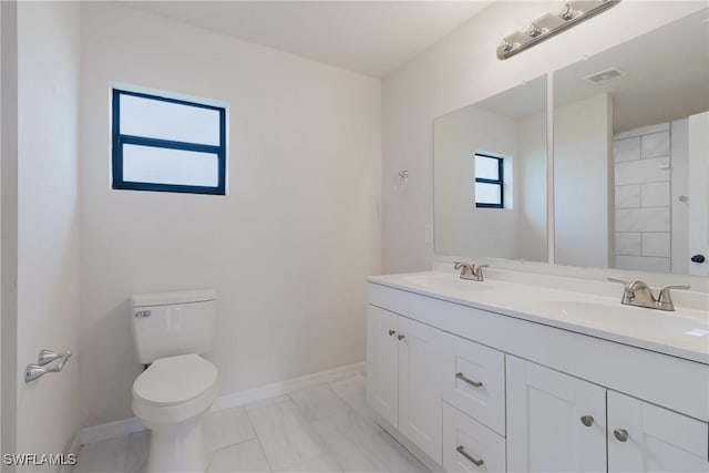 bathroom with a sink, baseboards, toilet, and marble finish floor