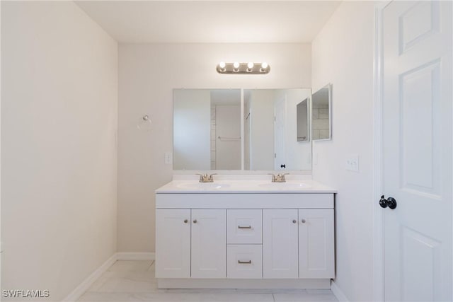 full bath featuring a sink, baseboards, and double vanity