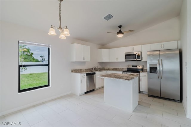 kitchen with hanging light fixtures, stainless steel appliances, visible vents, white cabinetry, and a kitchen island