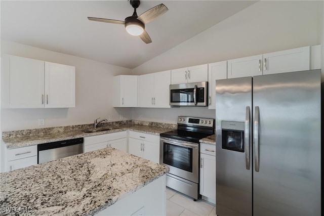 kitchen with stainless steel appliances, light stone countertops, white cabinetry, ceiling fan, and vaulted ceiling