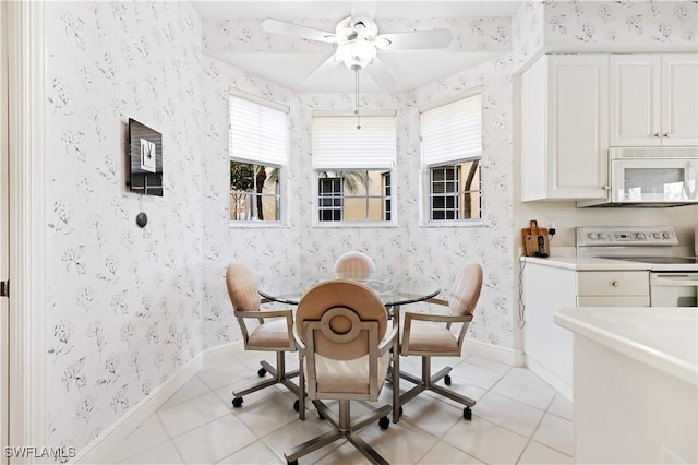 dining area featuring light tile patterned flooring, wallpapered walls, and baseboards