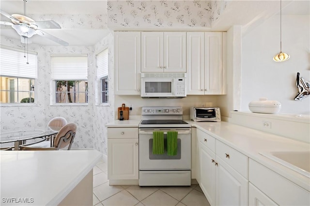 kitchen with white appliances, a ceiling fan, wallpapered walls, light countertops, and white cabinets