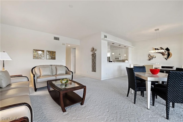 living area with visible vents, baseboards, and carpet