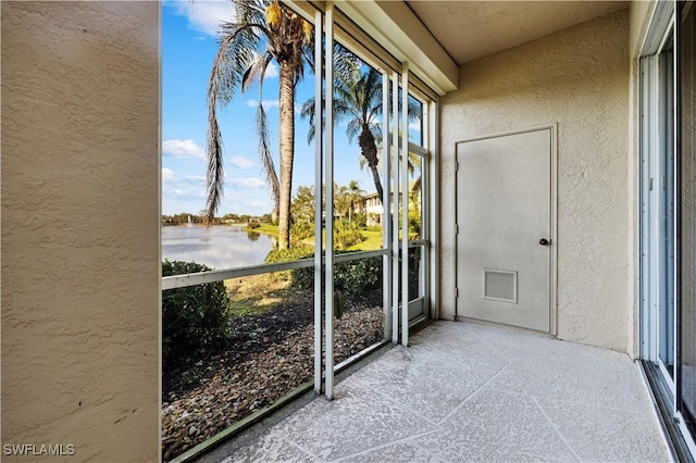 unfurnished sunroom with a water view