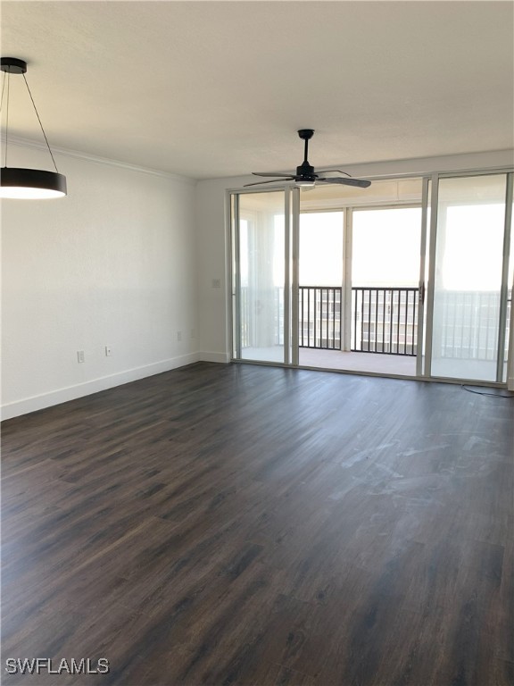 spare room with a ceiling fan, baseboards, and dark wood-style floors