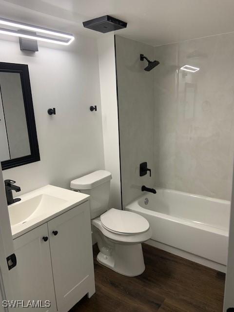 bathroom with vanity, shower / bathtub combination, wood finished floors, and toilet