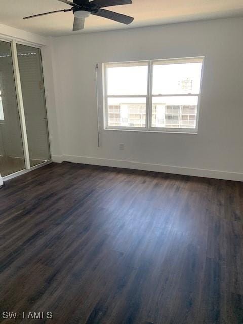 unfurnished bedroom featuring ceiling fan, baseboards, and dark wood-style floors