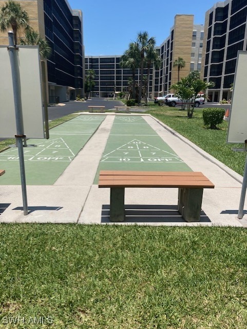 view of home's community with a lawn and shuffleboard