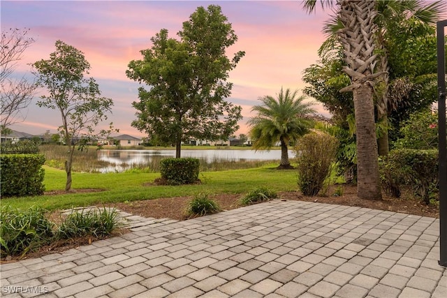 view of home's community featuring a patio area, a water view, and a lawn