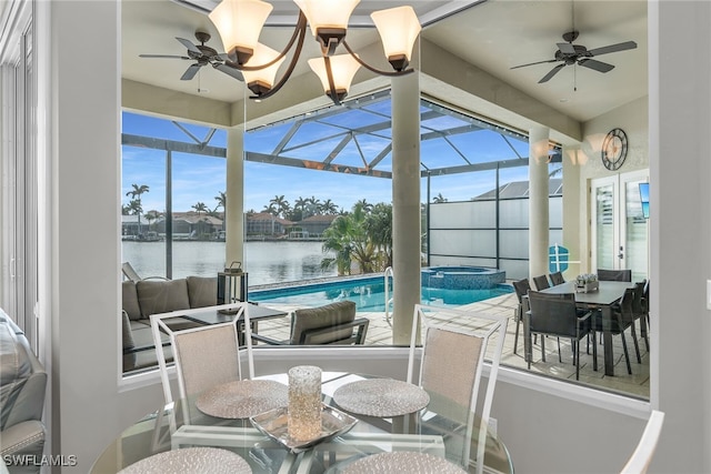 sunroom / solarium featuring a ceiling fan, a healthy amount of sunlight, and a water view