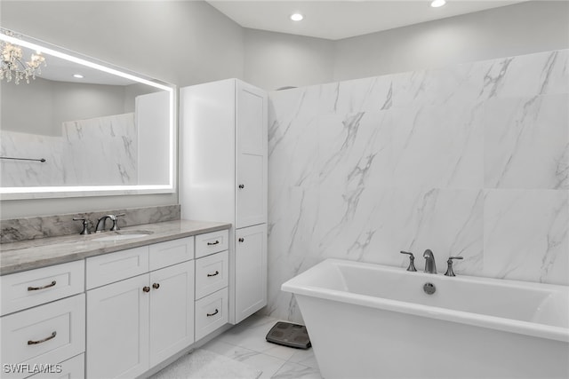 bathroom featuring a freestanding bath, marble finish floor, vanity, and recessed lighting