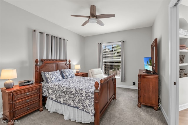 bedroom featuring a ceiling fan, light colored carpet, and baseboards