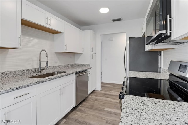 kitchen featuring stainless steel appliances, white cabinets, and a sink