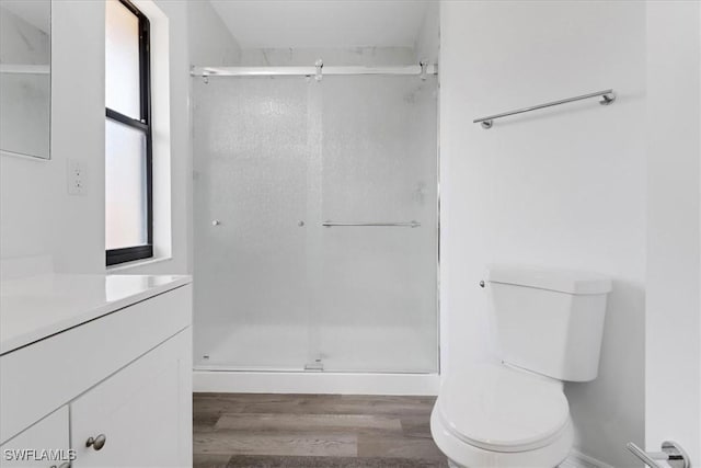 full bathroom with toilet, a stall shower, wood finished floors, and vanity