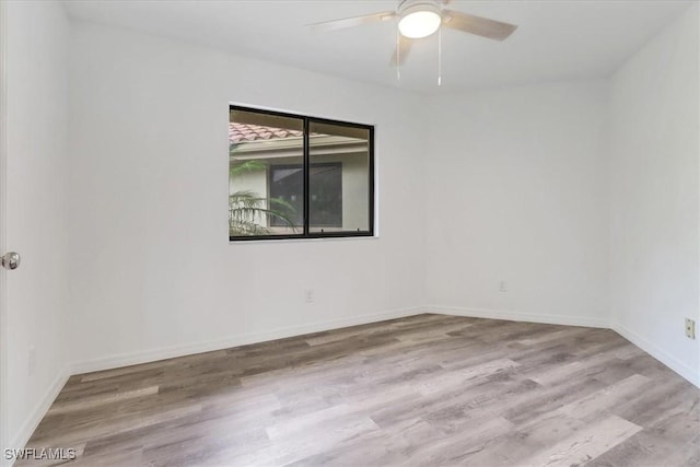 unfurnished room with light wood-type flooring, a ceiling fan, and baseboards